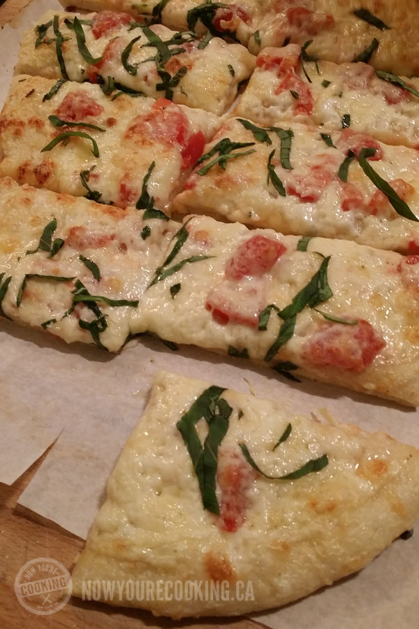 White sauce pizza with tomato, basil and mozzarella cheese.